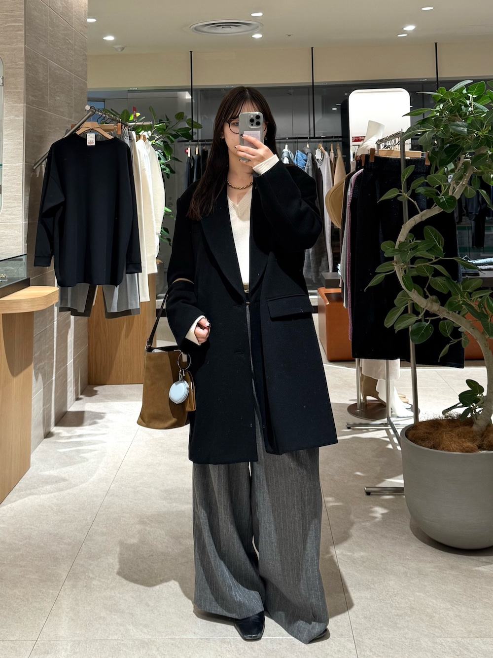 ブラック系のその他アウター、グレー系のスラックスを着用したレディースの冬コーディネートの3枚目の写真