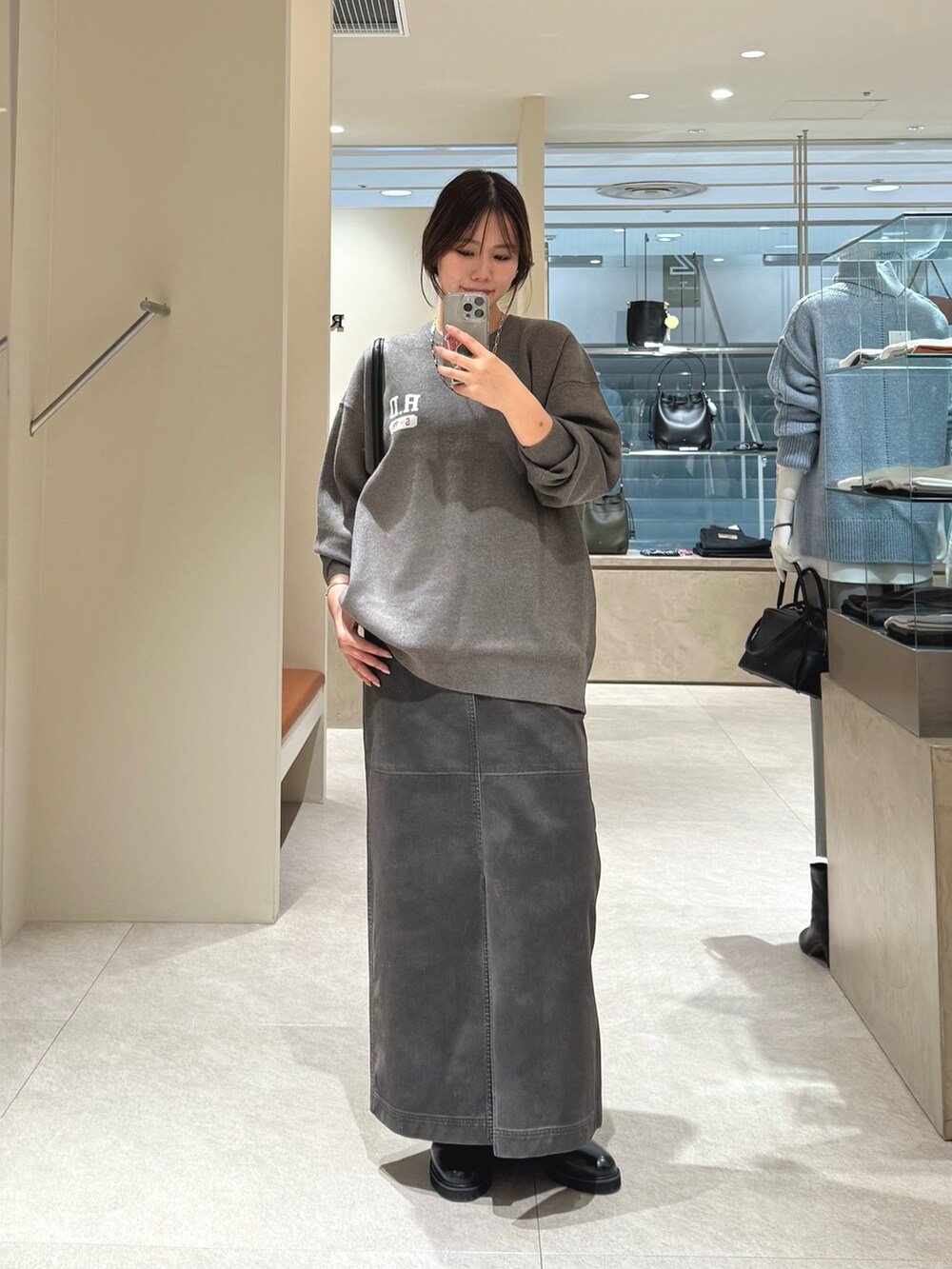 グレー系のニット/セーター、グレー系のスカートを着用したレディースの秋コーディネートの3枚目の写真