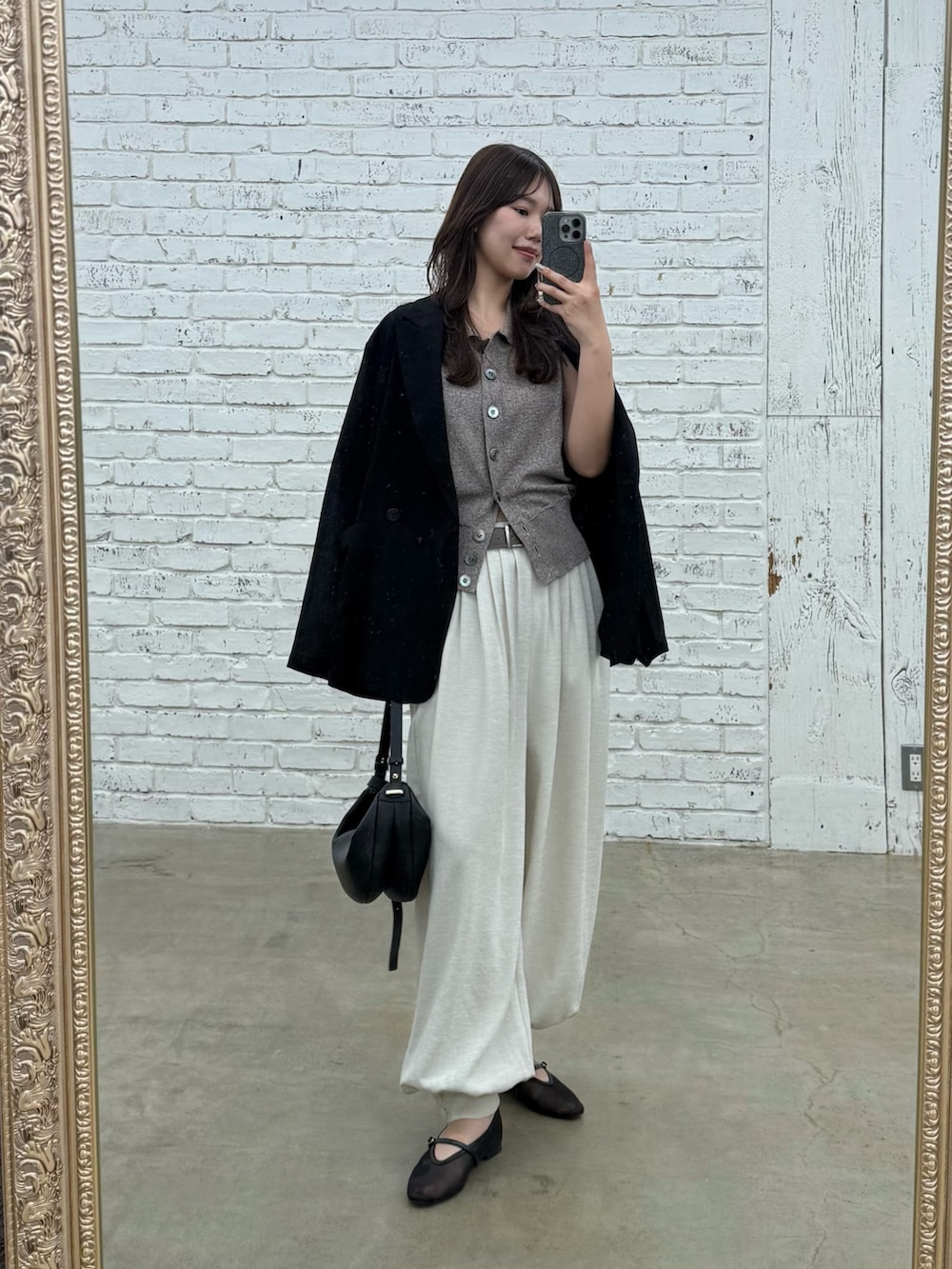 ベージュ系のその他パンツ、ブラウン系のニット/セーター、ブラック系のテーラードジャケットを着用したレディースの春コーディネートの3枚目の写真