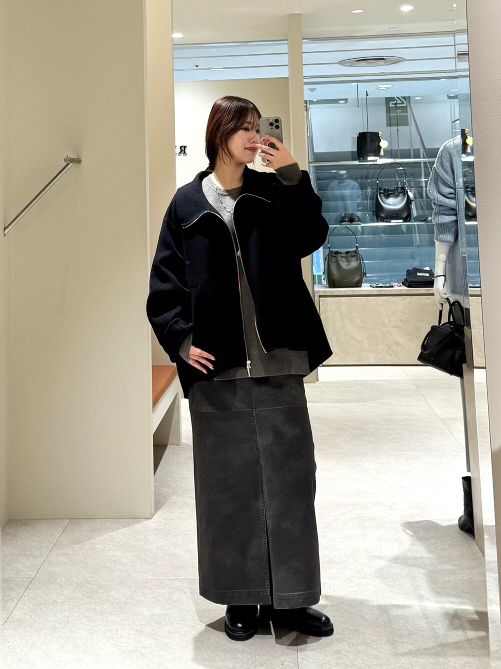 ブラック系のその他アウター、グレー系のスカート、グレー系のニット/セーターを着用したレディースの冬コーディネートの3枚目の写真