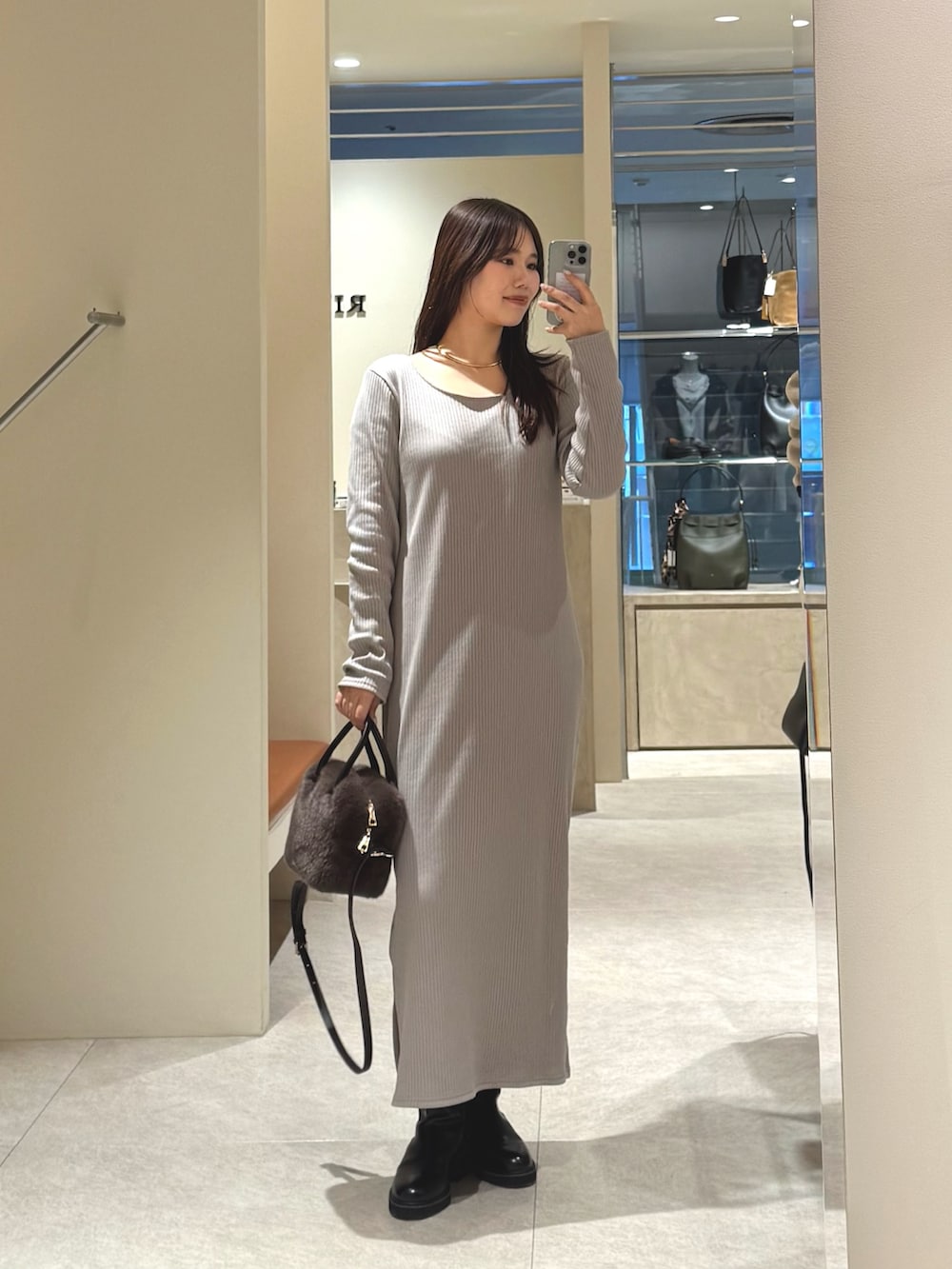 ベージュ系のワンピース、ブラウン系のボストンバッグを着用したレディースの冬コーディネートの2枚目の写真