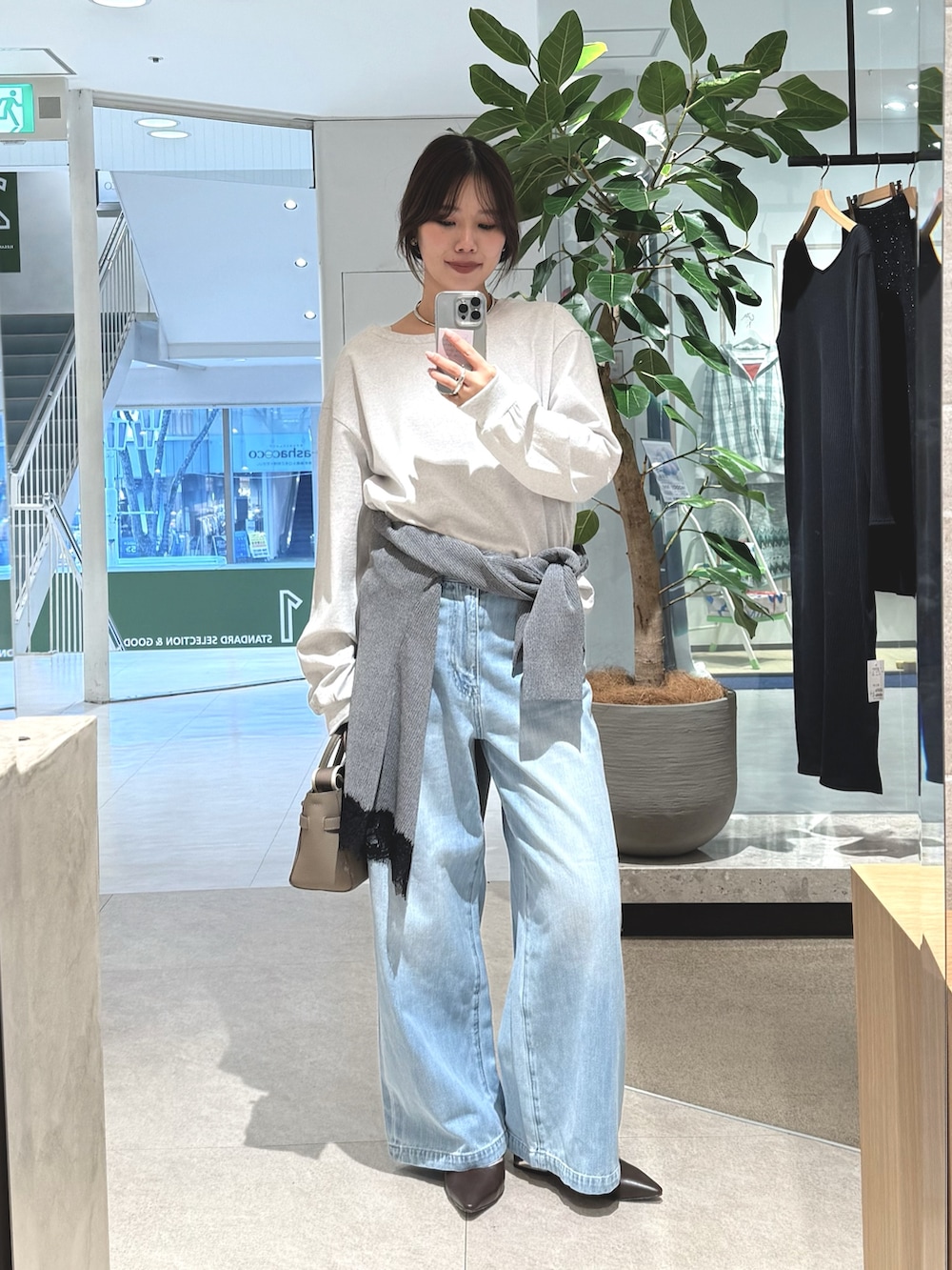 ブルー系のデニムパンツ、グレー系のTシャツ/カットソー、グレー系のカーディガン/ボレロを着用したレディースの冬コーディネートの2枚目の写真