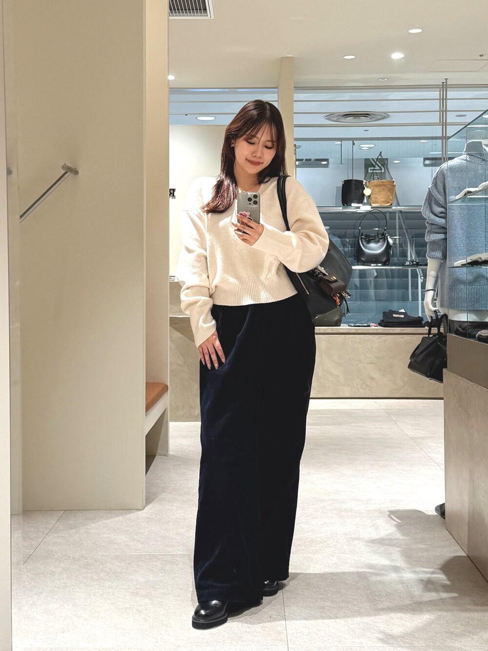 グレー系のその他アウター、ブラック系のその他パンツ、ホワイト系のニット/セーターを着用したレディースの冬コーディネートの5枚目の写真