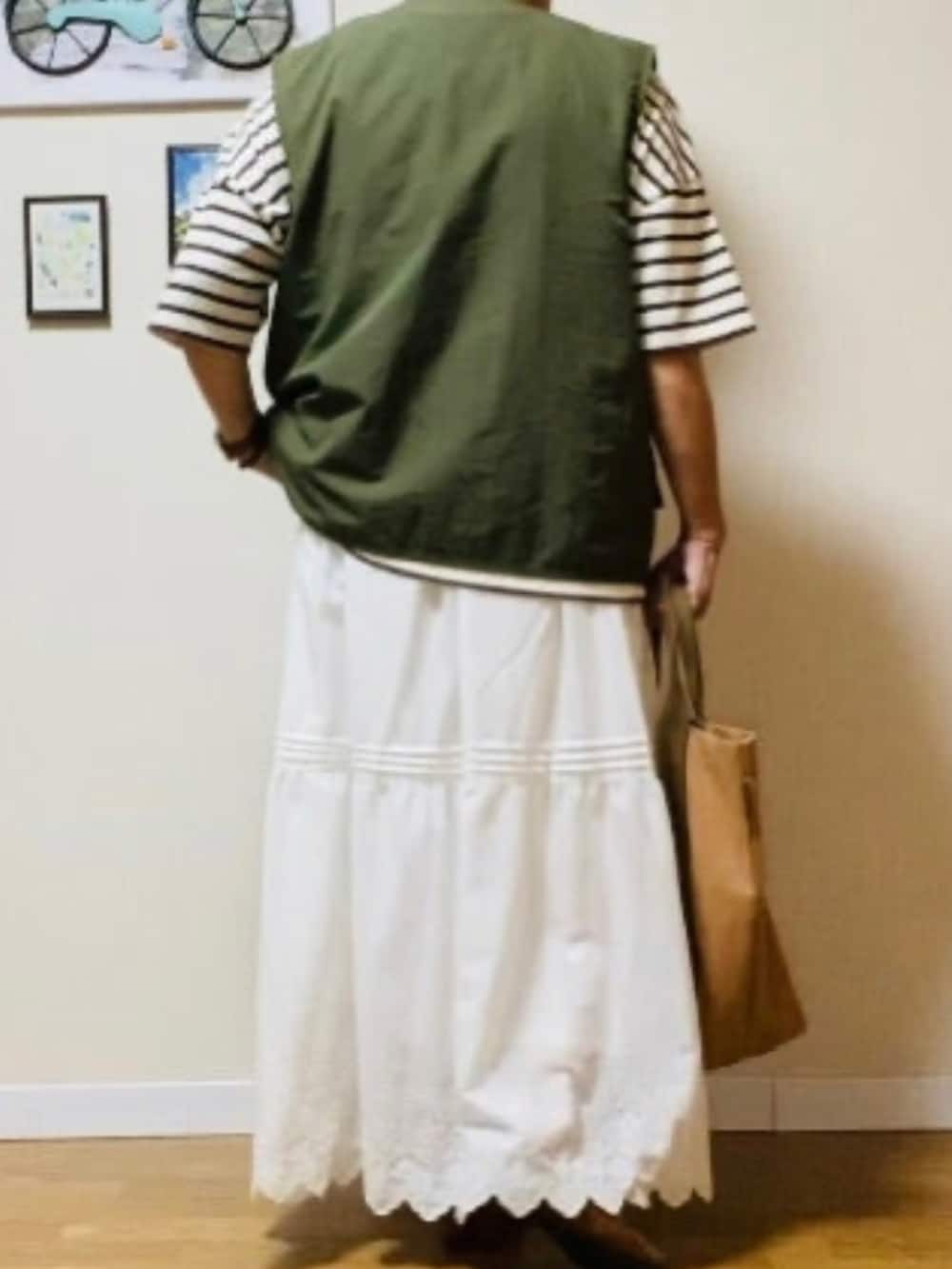 グリーン系のミリタリージャケット、ホワイト系のTシャツ/カットソー、ホワイト系のスカートを着用したレディースの秋コーディネートの3枚目の写真