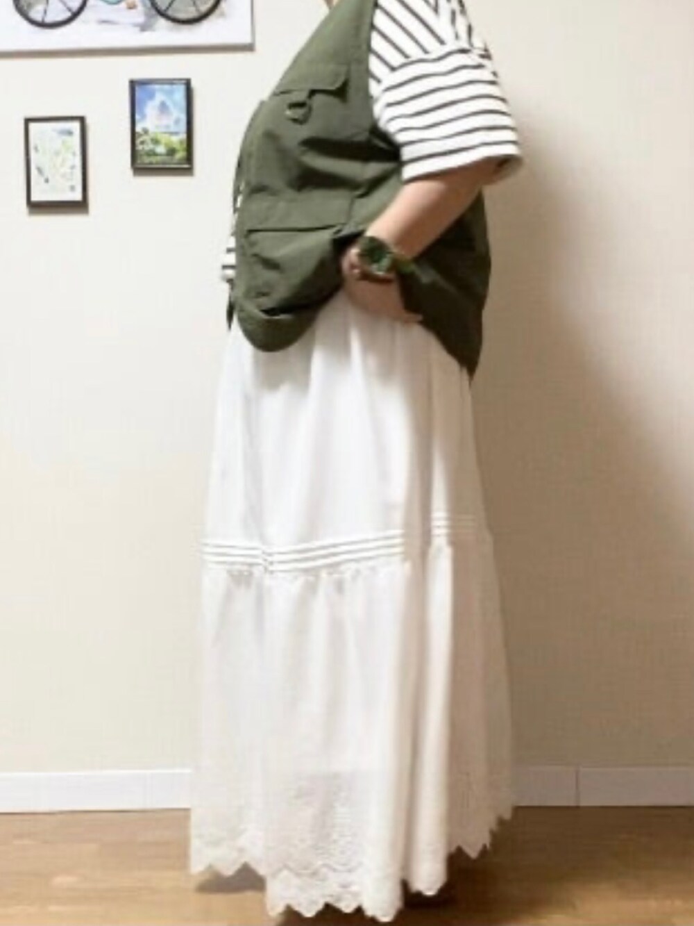 グリーン系のミリタリージャケット、ホワイト系のTシャツ/カットソー、ホワイト系のスカートを着用したレディースの秋コーディネートの2枚目の写真