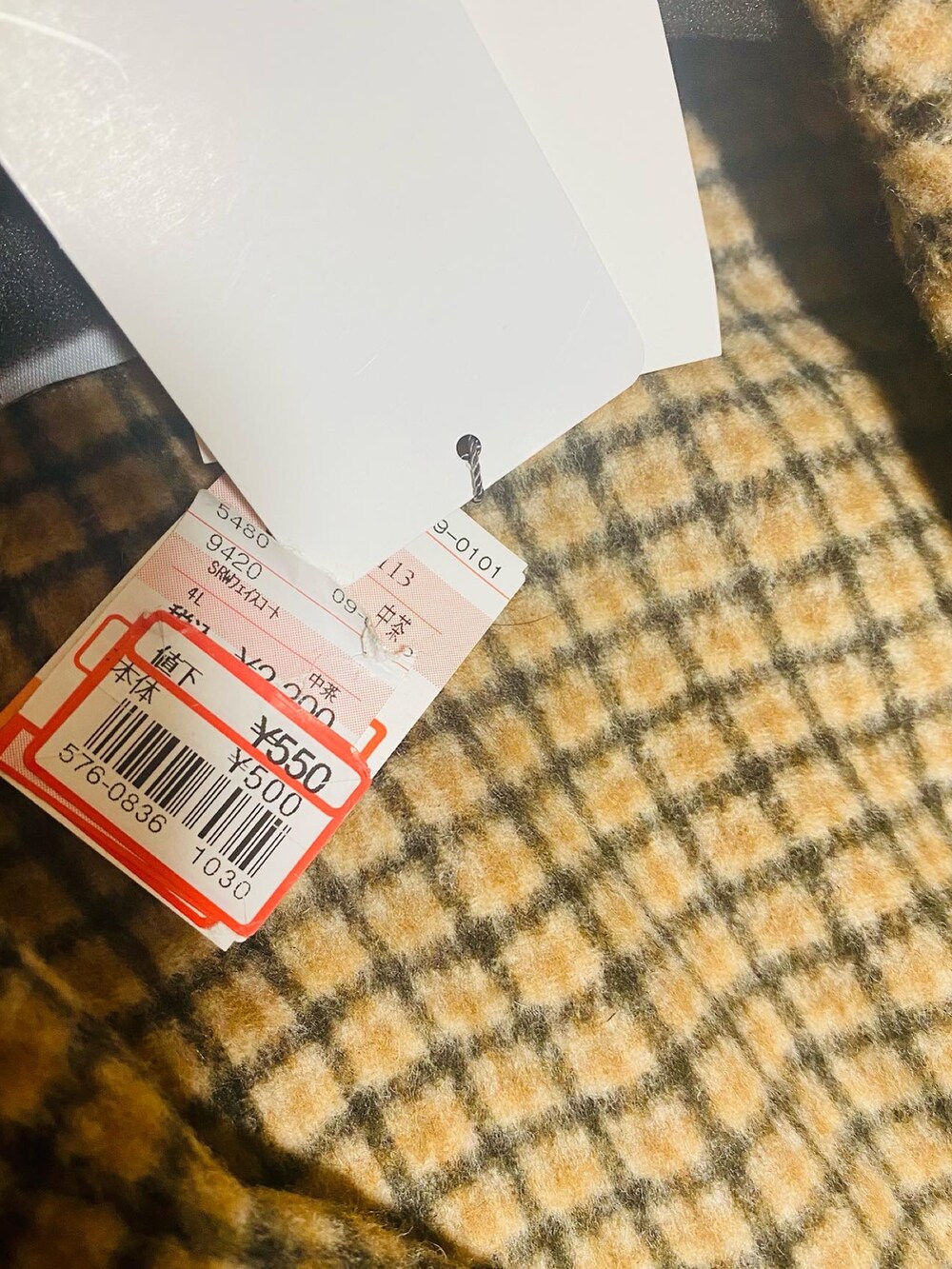 ベージュ系のトレンチコート、ブラック系のパーカー、イエロー系のTシャツ/カットソーを着用したレディースの冬コーディネートの4枚目の写真