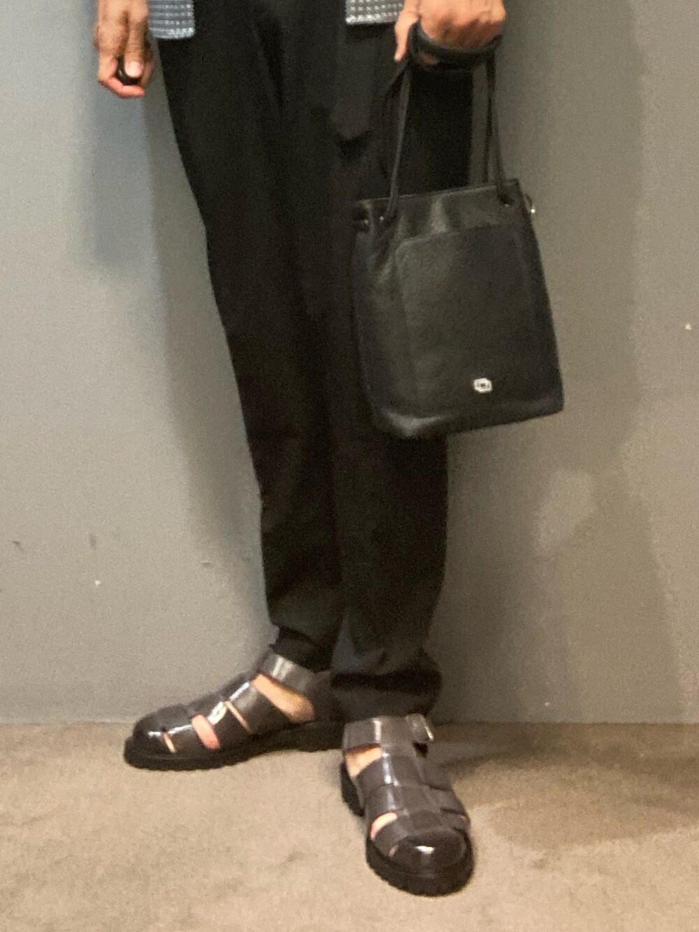 グレー系のサンダル、ブラック系のトートバッグを着用したメンズの夏コーディネートの3枚目の写真