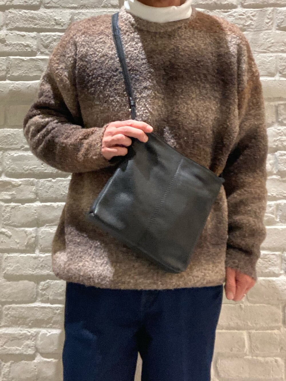 ブラック系のボディバッグ/ウエストポーチ、ブラウン系のブーツ、ブラック系のブーツを着用したメンズの冬コーディネートの2枚目の写真