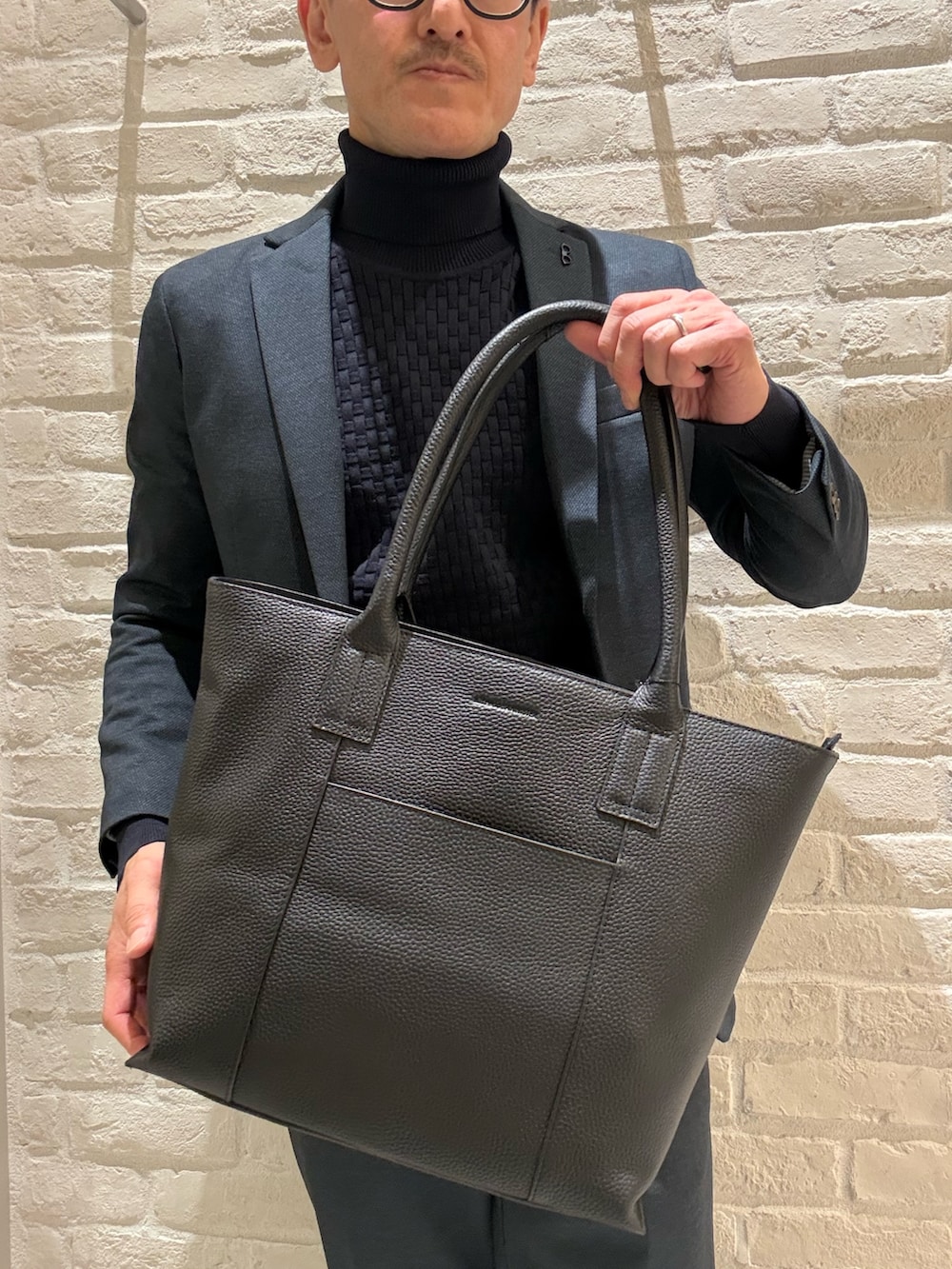 ブラック系のトートバッグを着用したメンズの冬コーディネートの3枚目の写真