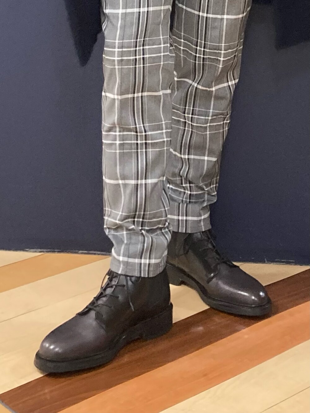 グレー系のショルダーバッグ、ブルー系のニット/セーター、ブルー系のチェスターコートを着用したメンズの冬コーディネートの3枚目の写真