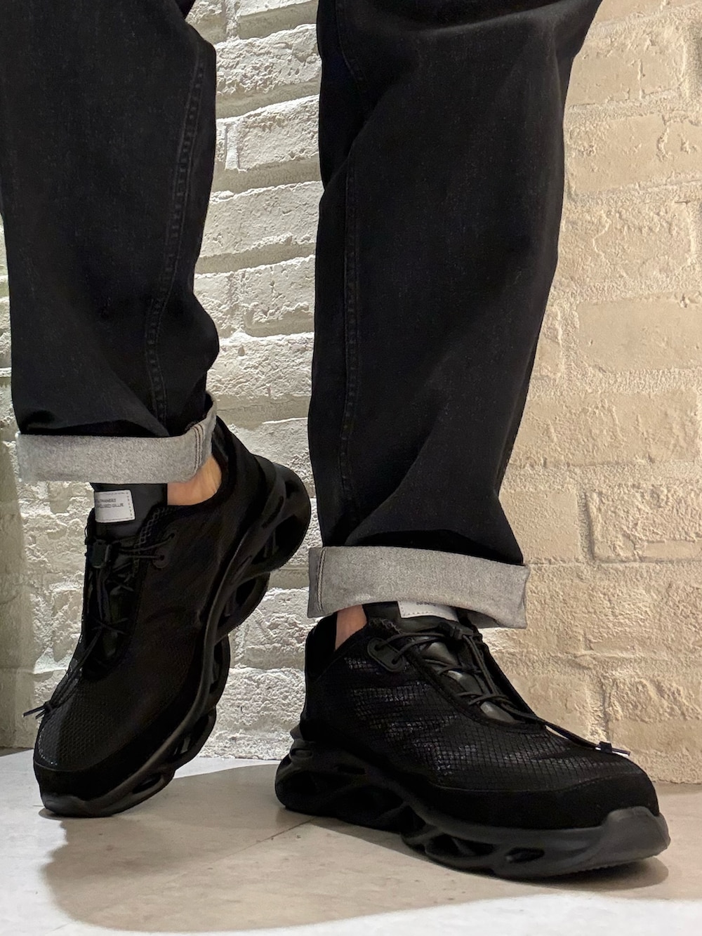 ブラック系のスニーカーを着用したメンズの春コーディネートの4枚目の写真