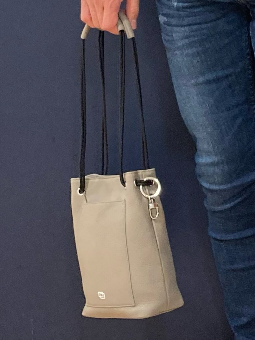 グレー系のスリッポン、グレー系のトートバッグ、ブルー系のデニムパンツを着用したメンズの春コーディネートの3枚目の写真