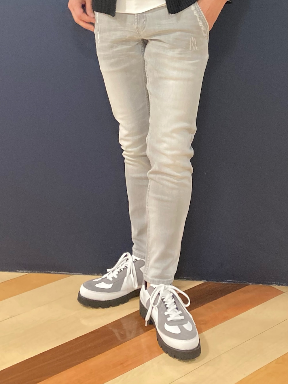 グレー系のデニムパンツ、ホワイト系のスニーカー、ブラック系のブルゾンを着用したメンズの冬コーディネートの3枚目の写真