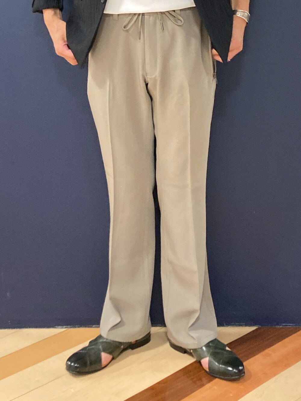 ブラック系のテーラードジャケット、ホワイト系のTシャツ/カットソー、グリーン系のスラックスを着用したメンズの春コーディネートの3枚目の写真