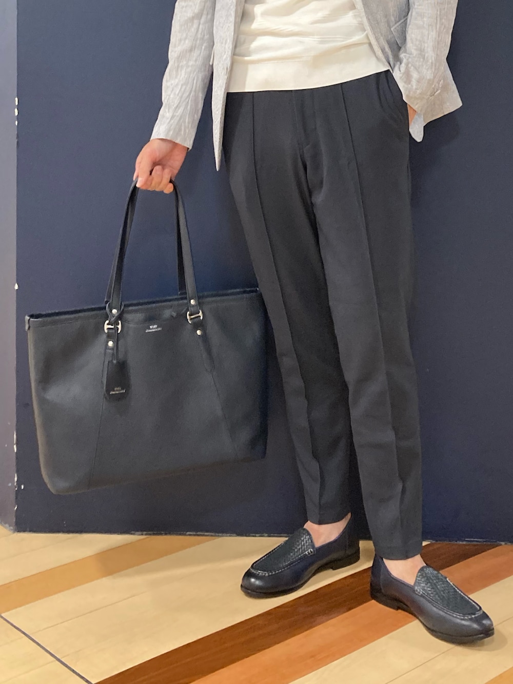 ブルー系のスリッポン、ブルー系のトートバッグ、ホワイト系のテーラードジャケットを着用したメンズの春コーディネートの3枚目の写真