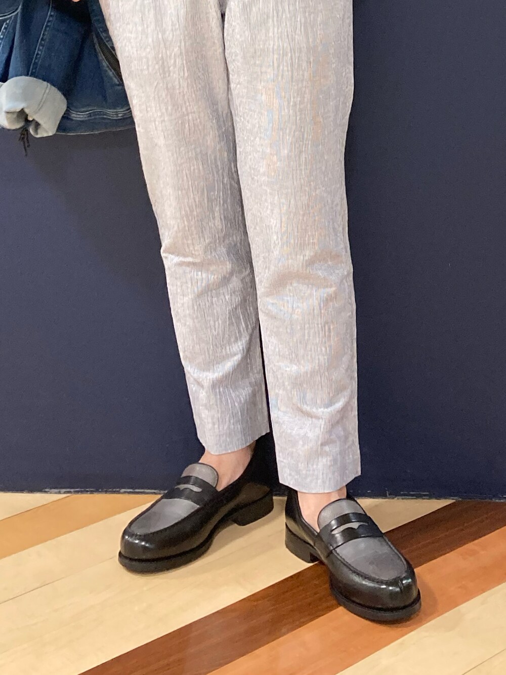 グレー系のローファー、ホワイト系のスラックス、ブラック系のTシャツ/カットソーを着用したメンズの夏コーディネートの3枚目の写真