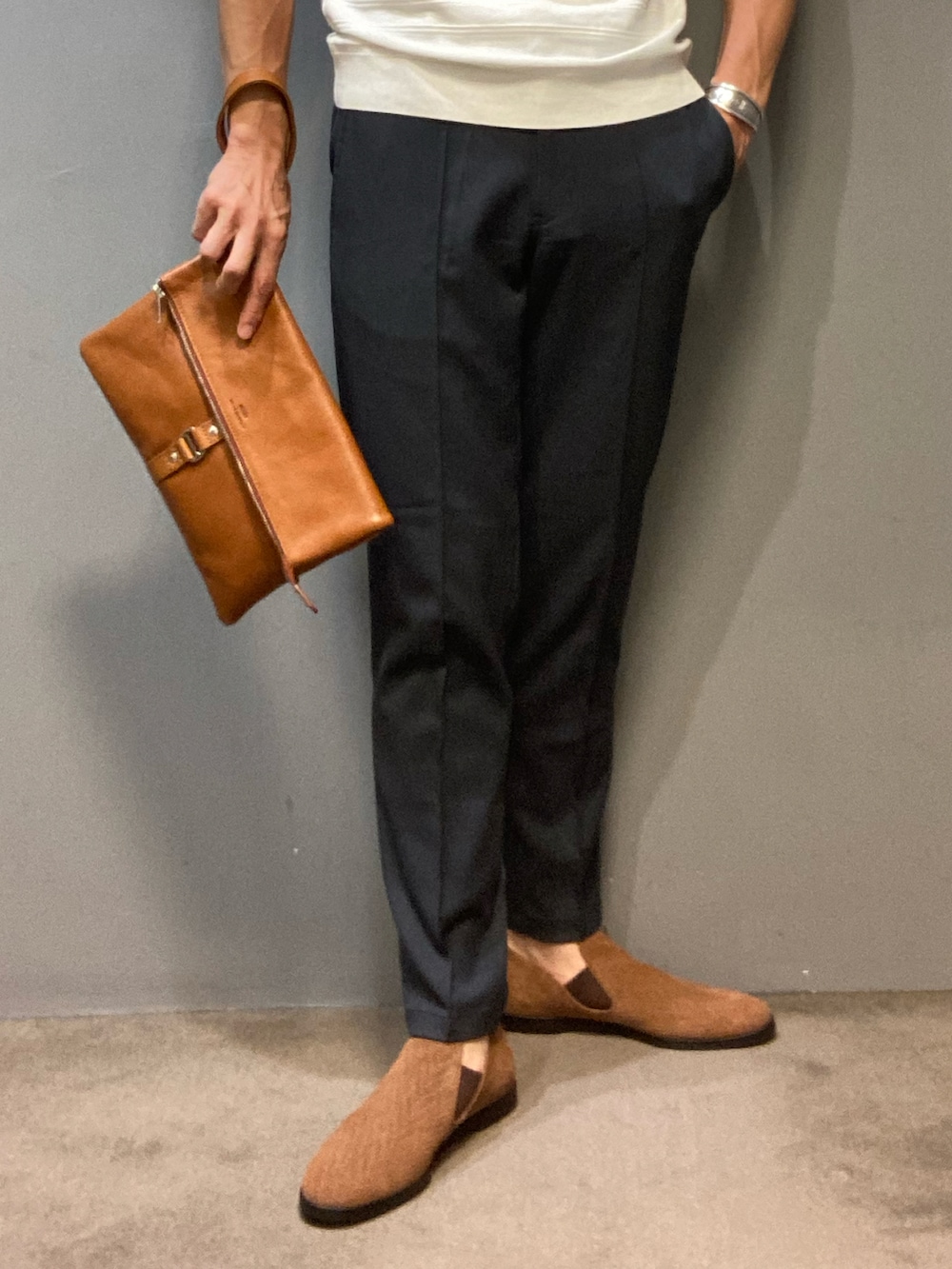 ホワイト系のTシャツ/カットソー、イエロー系のクラッチバッグ、ブルー系のその他パンツを着用したメンズの春コーディネートの2枚目の写真