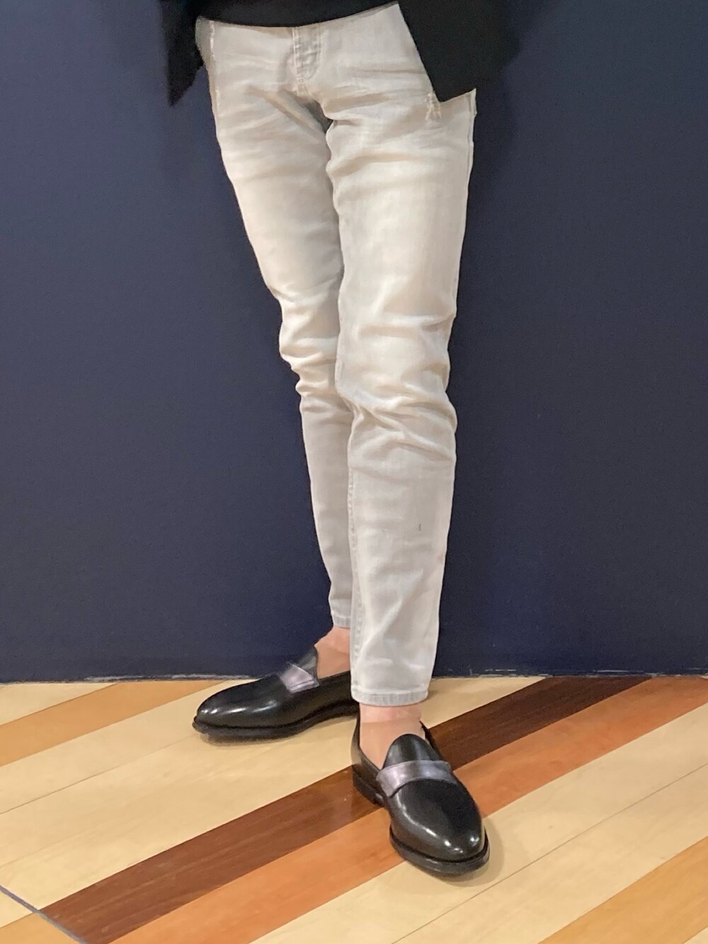 グレー系のデニムパンツ、その他のローファー、ブラック系のポロシャツを着用したメンズの冬コーディネートの2枚目の写真