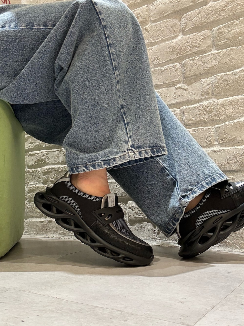 シルバー系のスニーカーを着用したメンズの春コーディネートの2枚目の写真