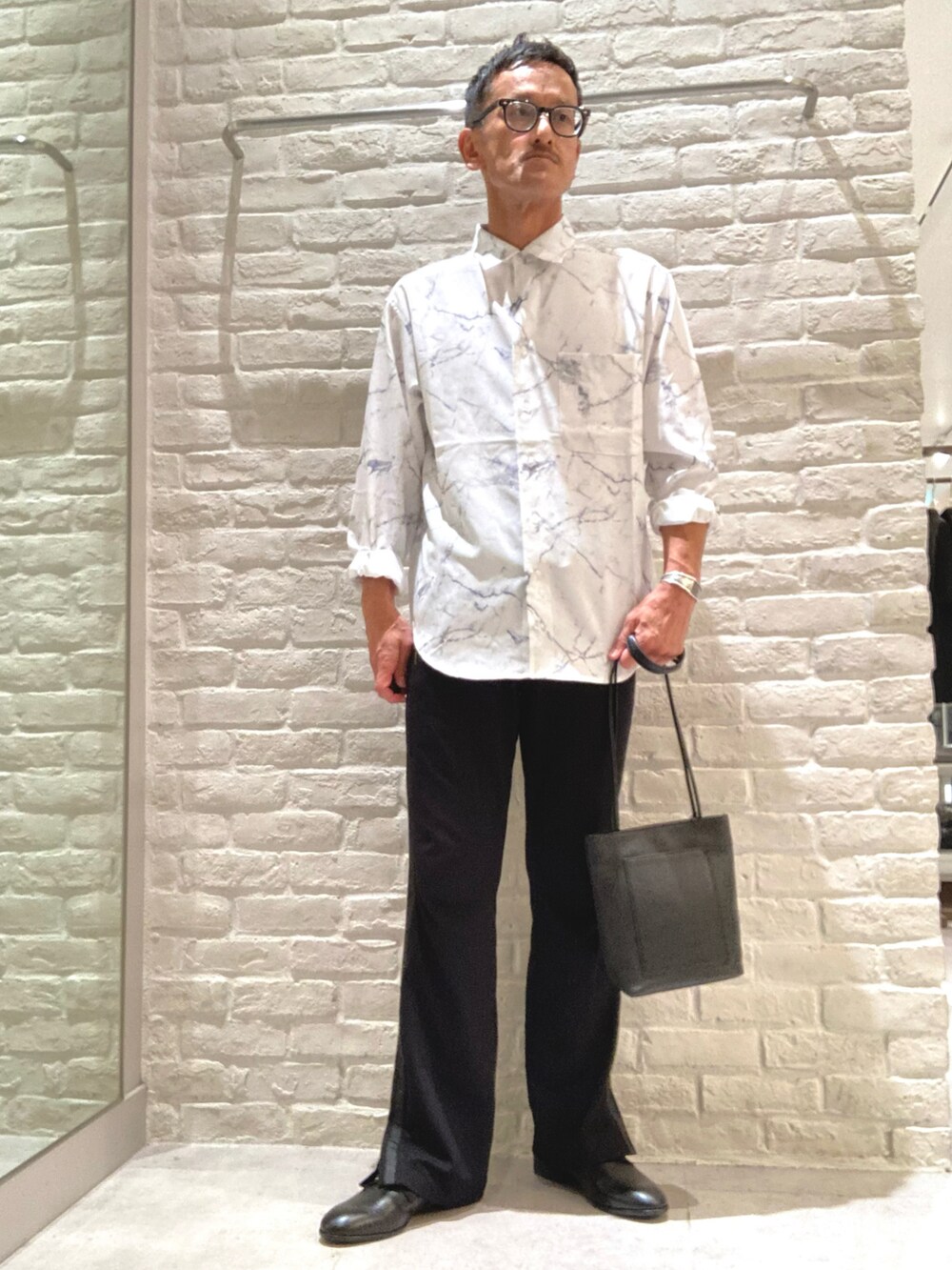 ブラック系のボディバッグ/ウエストポーチ、ブラック系のローファーを着用したメンズの秋コーディネートの2枚目の写真