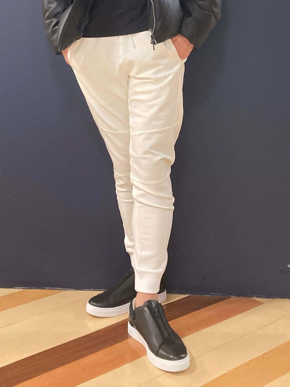 ブラック系のジャケット/アウター、ブラック系のTシャツ/カットソー、ホワイト系のスウェットパンツを着用したメンズの冬コーディネートの2枚目の写真