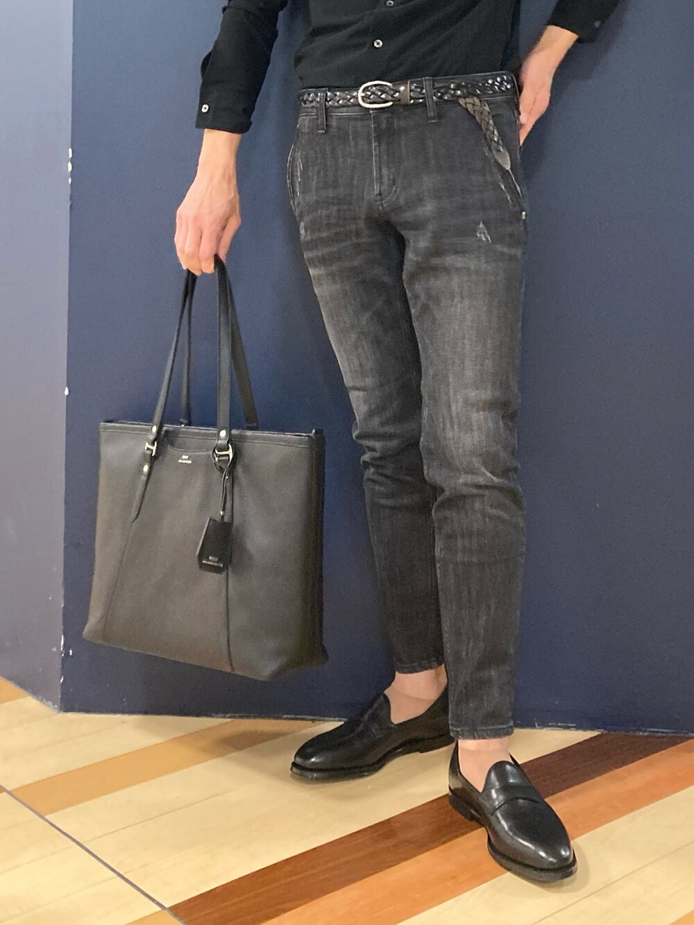 ブラック系のトートバッグ、ブラック系のローファー、ブラック系のデニムパンツを着用したメンズの冬コーディネートの2枚目の写真
