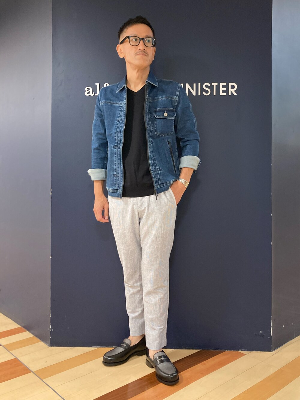 グレー系のローファー、ホワイト系のスラックス、ブラック系のTシャツ/カットソーを着用したメンズの夏コーディネートの2枚目の写真