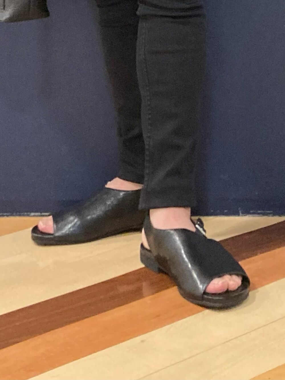 ブラック系のサンダル、ブラック系のデニムパンツ、ブラック系のトートバッグを着用したメンズの春コーディネートの3枚目の写真