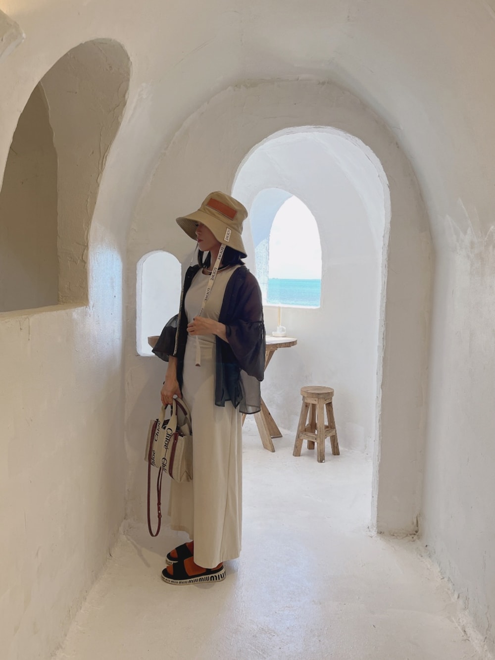 ベージュ系のワンピース、ベージュ系のショルダーバッグ、ベージュ系のハットを着用したレディースの秋コーディネートの2枚目の写真