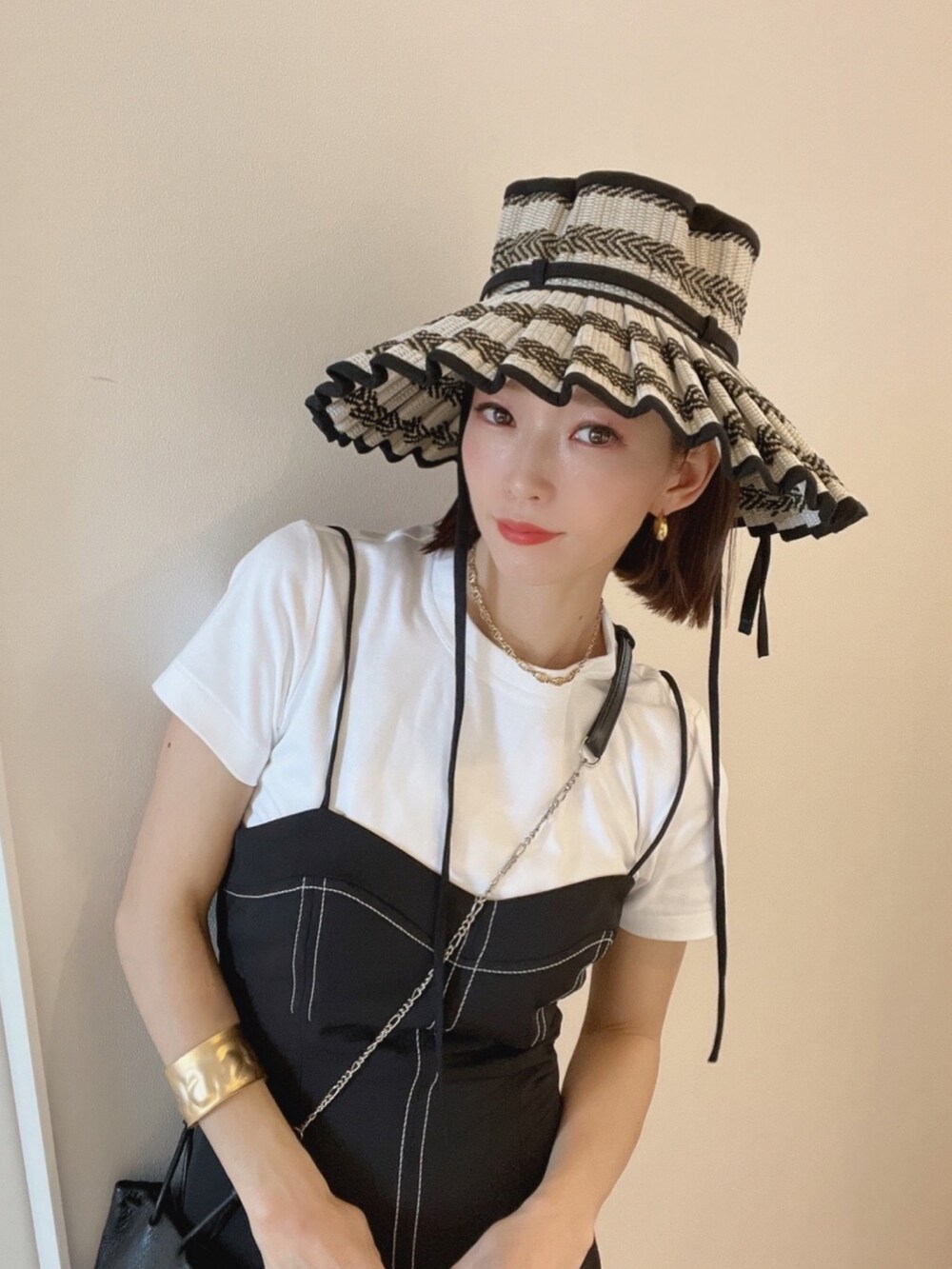 ホワイト系のサンダル、ブラック系のワンピース/ドレス、ホワイト系のTシャツ/カットソーを着用したレディースの夏コーディネートの4枚目の写真