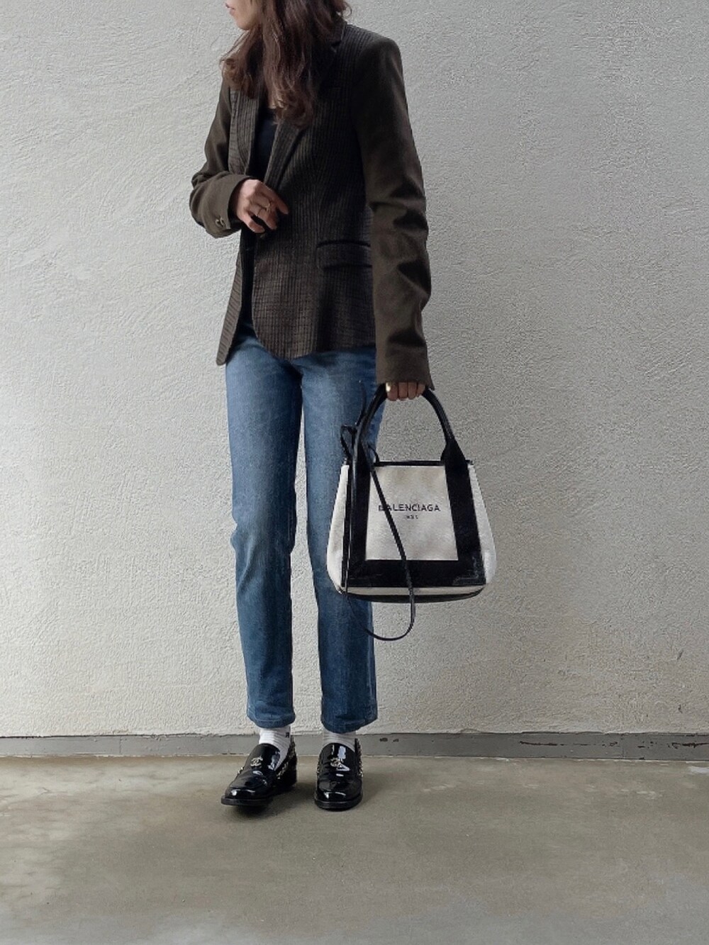 ブルー系のデニムパンツ、ホワイト系のトートバッグ、ブラック系のシューズを着用したレディースの冬コーディネートの2枚目の写真