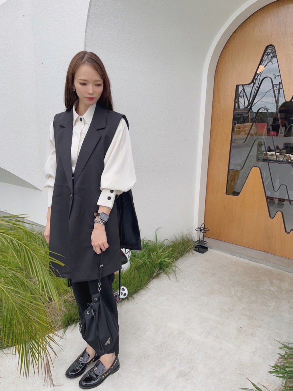 ブラック系のベストを着用したレディースの秋コーディネートの3枚目の写真