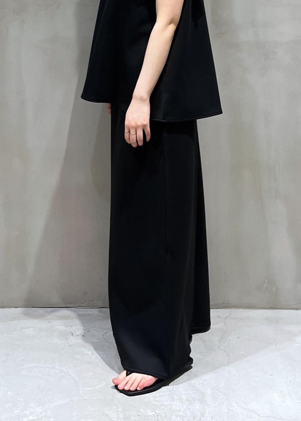 ブラック系のサンダル、ブラック系のスカート、ブラック系のTシャツ/カットソーを着用したレディースの夏コーディネートの3枚目の写真