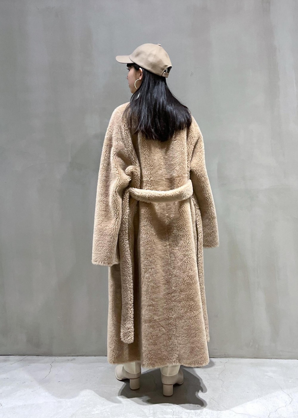 ホワイト系のニット/セーター、ホワイト系のスラックス、ホワイト系のブーツを着用したレディースの冬コーディネートの2枚目の写真