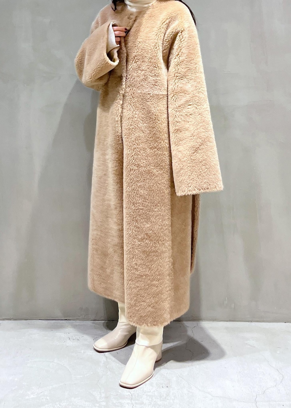 ホワイト系のニット/セーター、ホワイト系のスラックス、ホワイト系のブーツを着用したレディースの冬コーディネートの4枚目の写真