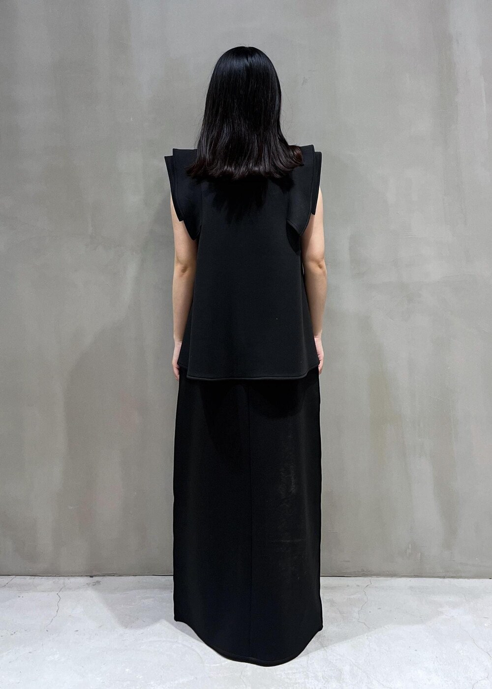 ブラック系のサンダル、ブラック系のスカート、ブラック系のTシャツ/カットソーを着用したレディースの夏コーディネートの2枚目の写真