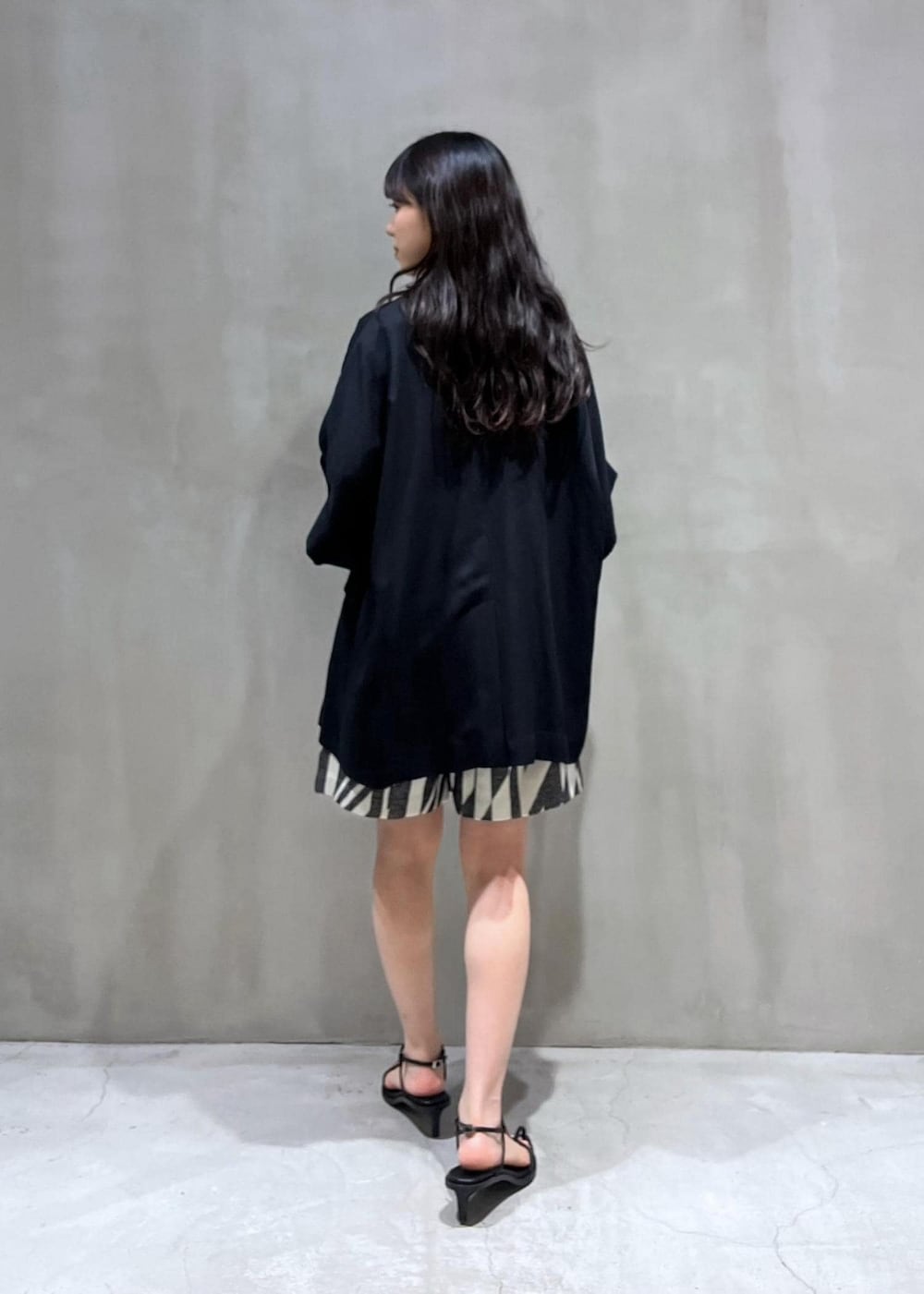 ブラック系のサンダル、ブラック系のテーラードジャケット、ブラック系のその他パンツを着用したレディースの春コーディネートの2枚目の写真