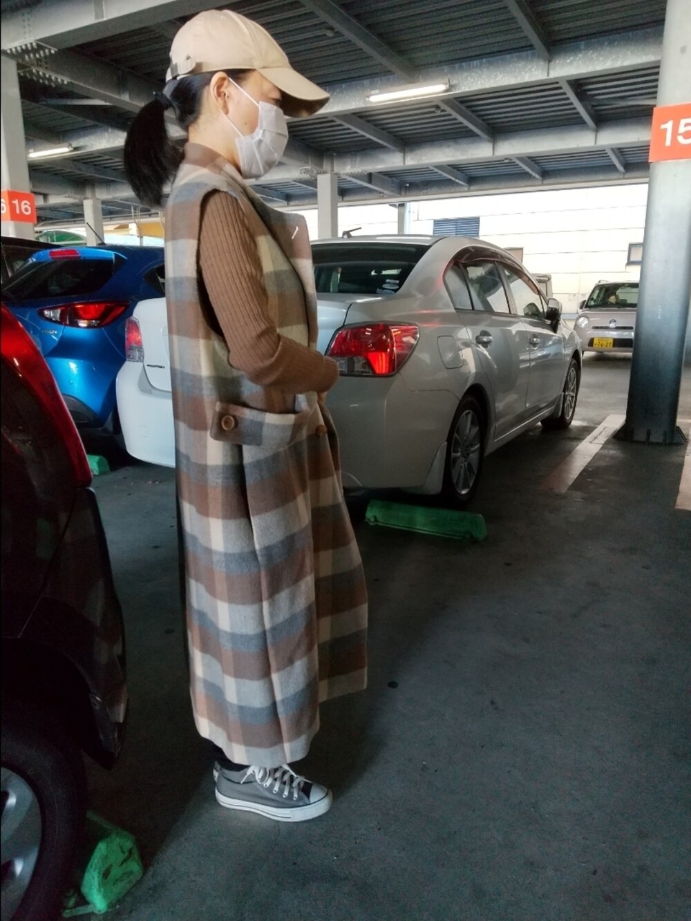 ブラウン系のニット/セーター、ブラック系のトートバッグ、ブラウン系のノーカラーコートを着用したレディースの秋コーディネートの2枚目の写真