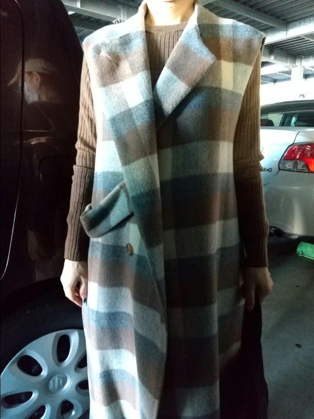 ブラウン系のニット/セーター、ブラック系のトートバッグ、ブラウン系のノーカラーコートを着用したレディースの秋コーディネートの3枚目の写真