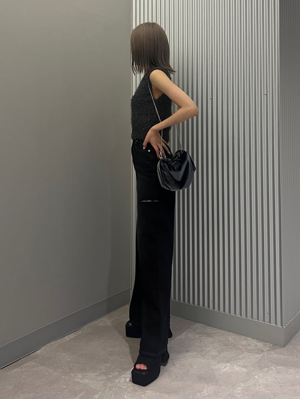ブラック系のデニムパンツ、グレー系のハンドバッグ、ブラック系のサンダルを着用したレディースの夏コーディネートの2枚目の写真