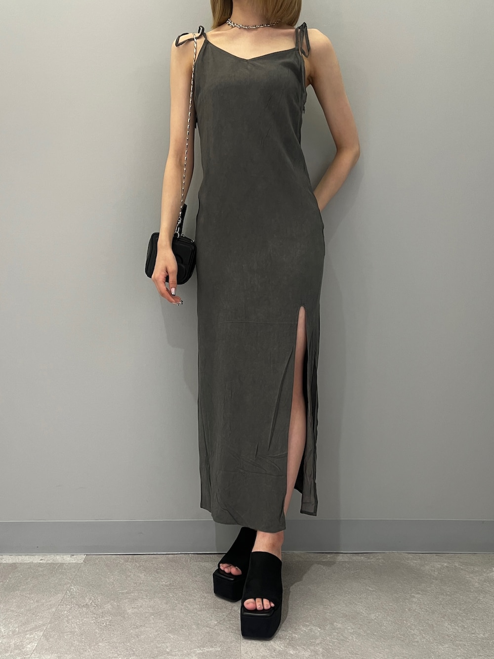 ブラック系のハンドバッグ、ブラック系のワンピース、ブラック系のサンダルを着用したレディースの夏コーディネートの5枚目の写真