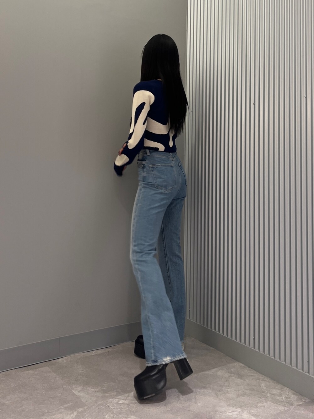 ブルー系のデニムパンツ、ブラック系のブーツ、グリーン系のキャミソールを着用したレディースの冬コーディネートの2枚目の写真