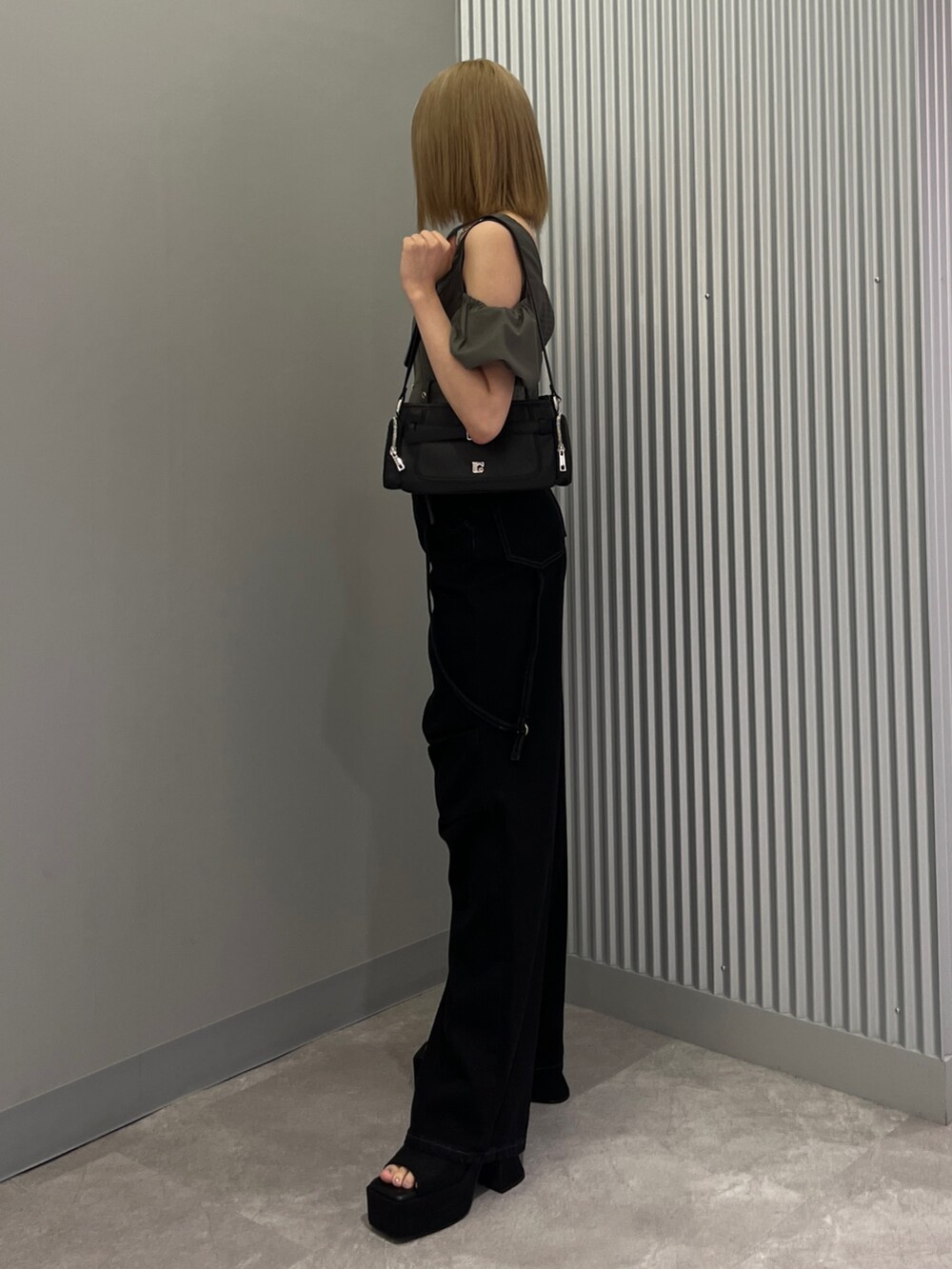 ブラック系のデニムパンツ、ブラック系のショルダーバッグ、ブラック系のサンダルを着用したレディースの夏コーディネートの2枚目の写真