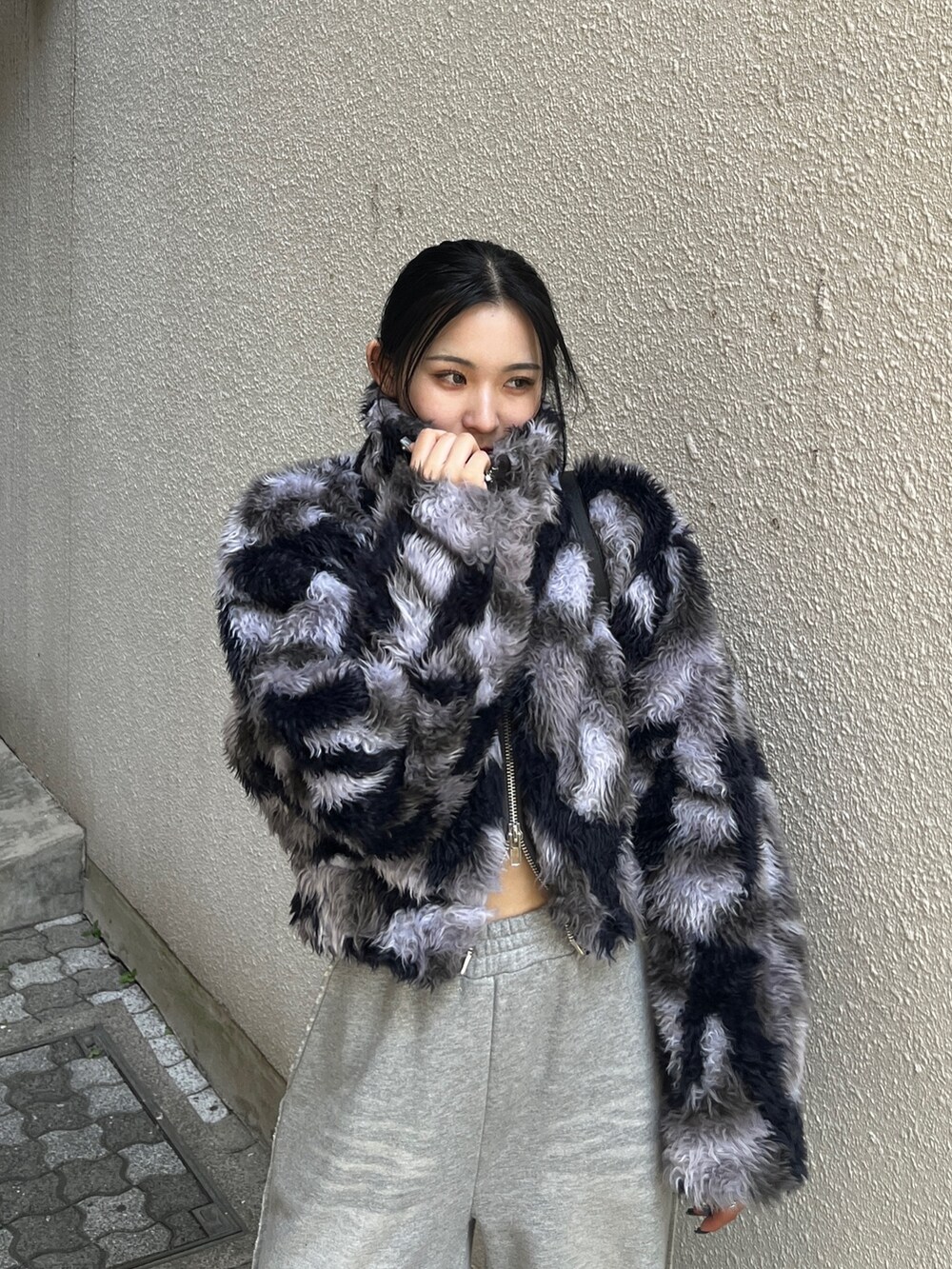 ブルー系のブルゾン、グレー系のスウェットパンツ、ブラック系のハンドバッグを着用したレディースの秋コーディネートの6枚目の写真