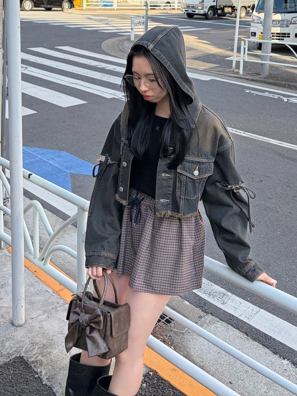 ブルー系のデニムジャケット、ブルー系のスカート、ブラック系のブーツを着用したレディースの冬コーディネートの4枚目の写真