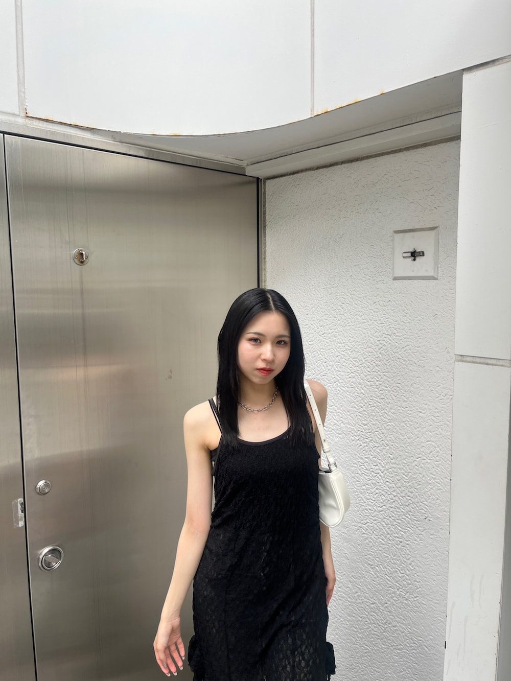 ブルー系のデニムパンツ、ホワイト系のショルダーバッグ、ブラック系のサンダルを着用したレディースの夏コーディネートの6枚目の写真