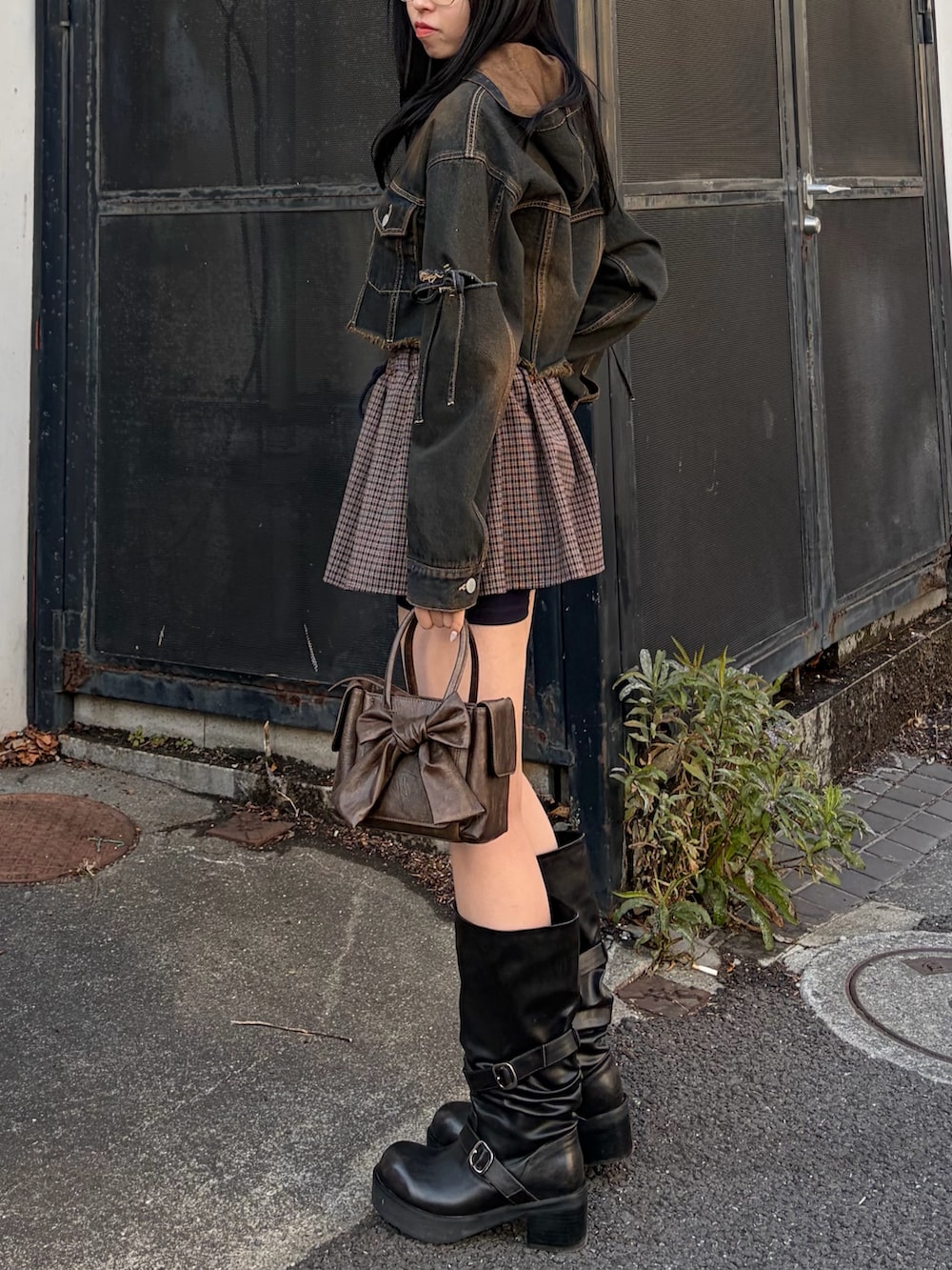 ブルー系のデニムジャケット、ブルー系のスカート、ブラック系のブーツを着用したレディースの冬コーディネートの2枚目の写真