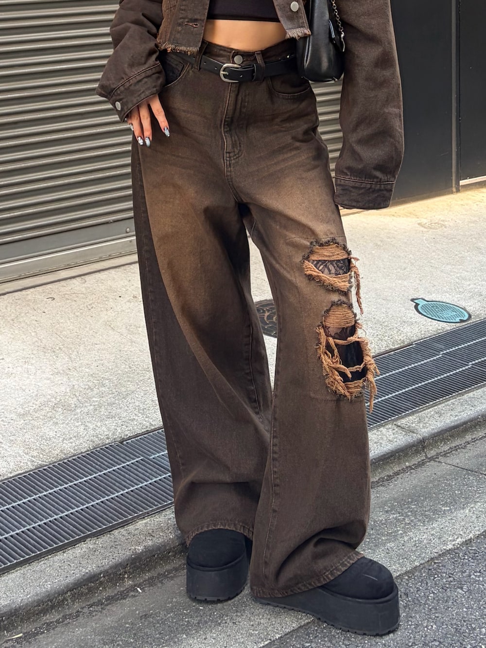 ブラック系のTシャツ/カットソー、ブラウン系のデニムパンツ、ブラック系のハンドバッグを着用したレディースの秋コーディネートの5枚目の写真