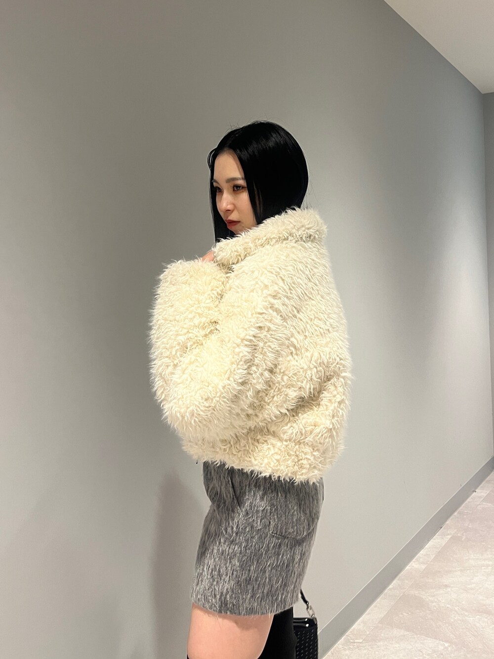 ホワイト系のブルゾン、ブラック系のカーディガン/ボレロ、グレー系のその他パンツを着用したレディースの冬コーディネートの4枚目の写真