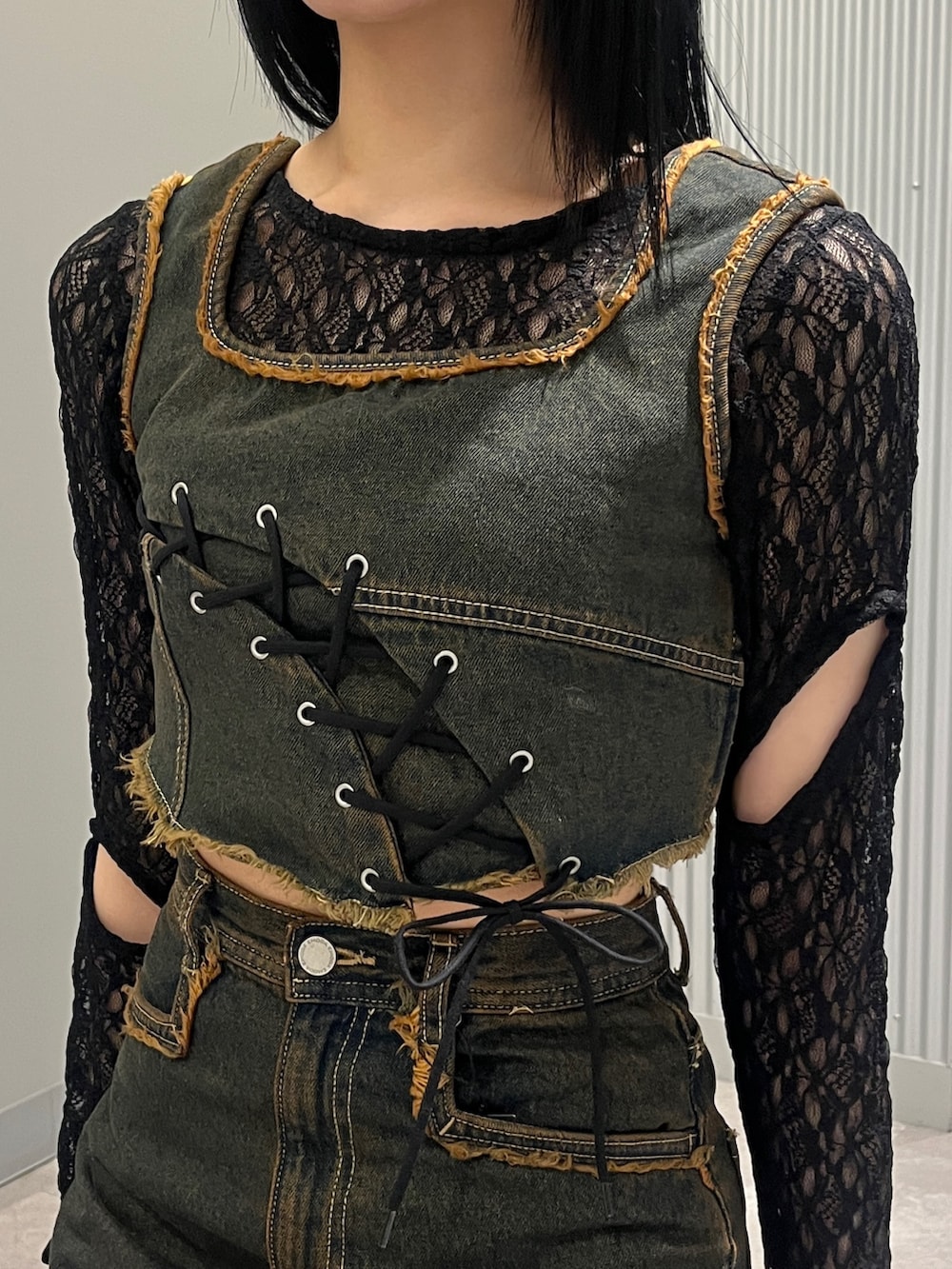 ブルー系のデニムパンツ、ブルー系のタンクトップ、ブラック系のTシャツ/カットソーを着用したレディースの春コーディネートの4枚目の写真